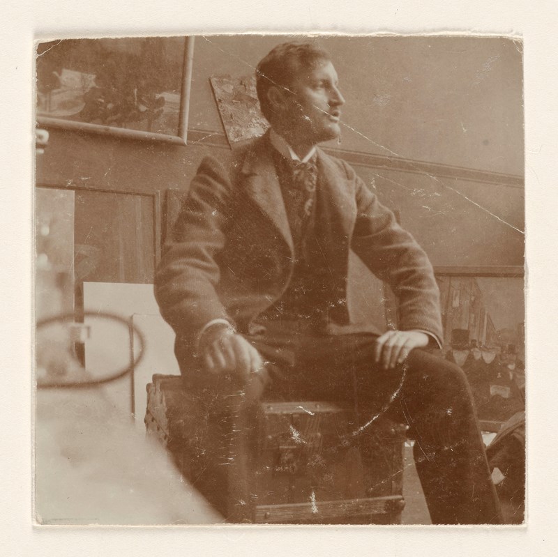 Edvard Munch: Edvard Munch på sin reisekoffert i atelieret i Lützowstrasse 82 I. Fotografi, 1902. Foto © Munchmuseet